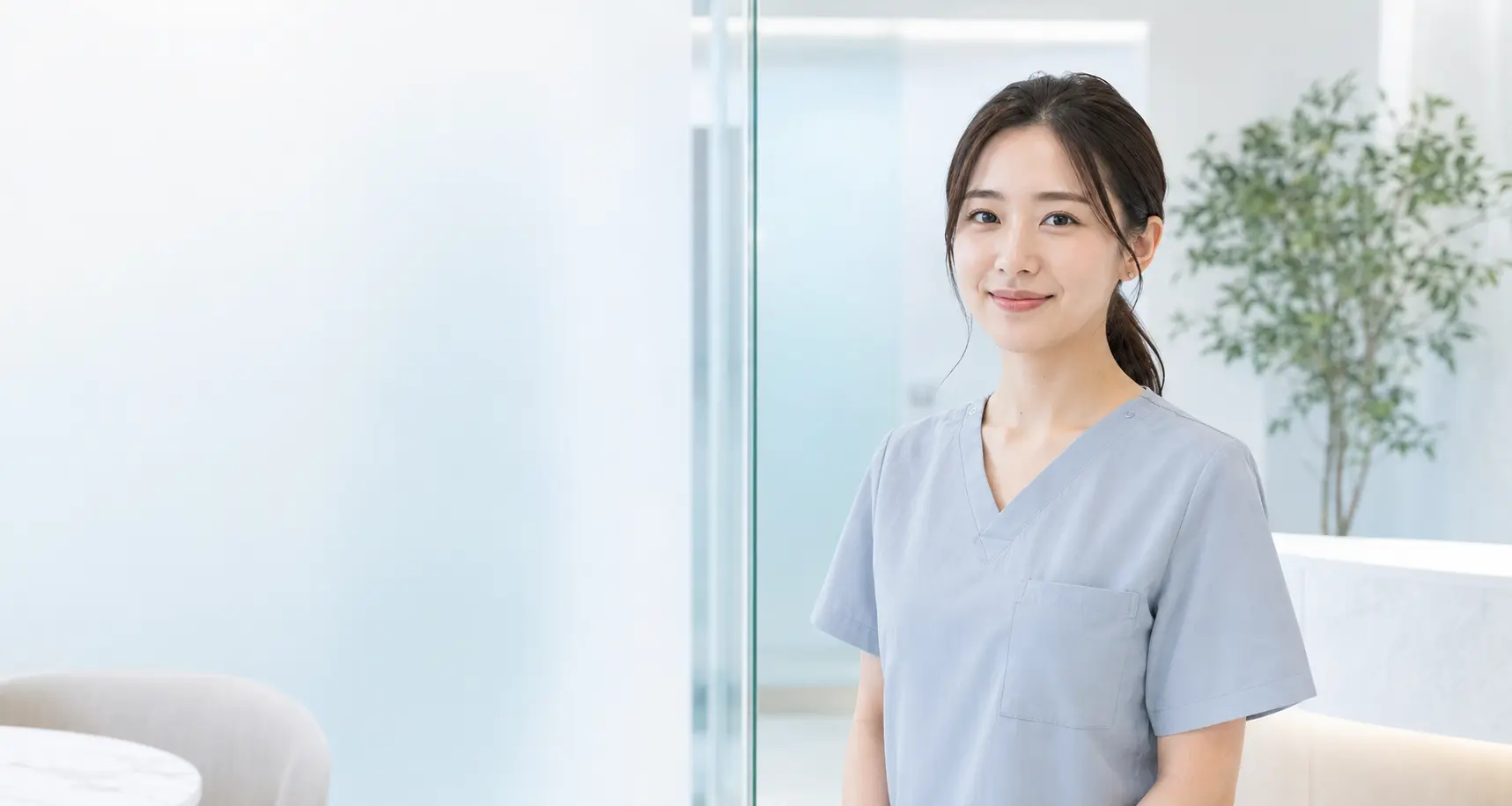 明るいクリニックに立つ美容看護師